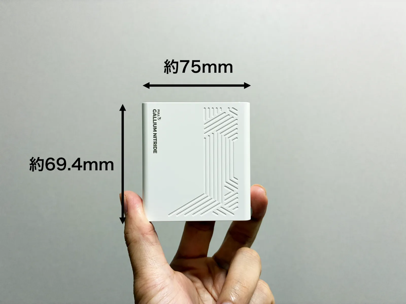 PHYSCE 100Wの模様が入った面を手に持って写した写真。横が約75mm、縦が約69.4mmと、寸法を矢印で示している