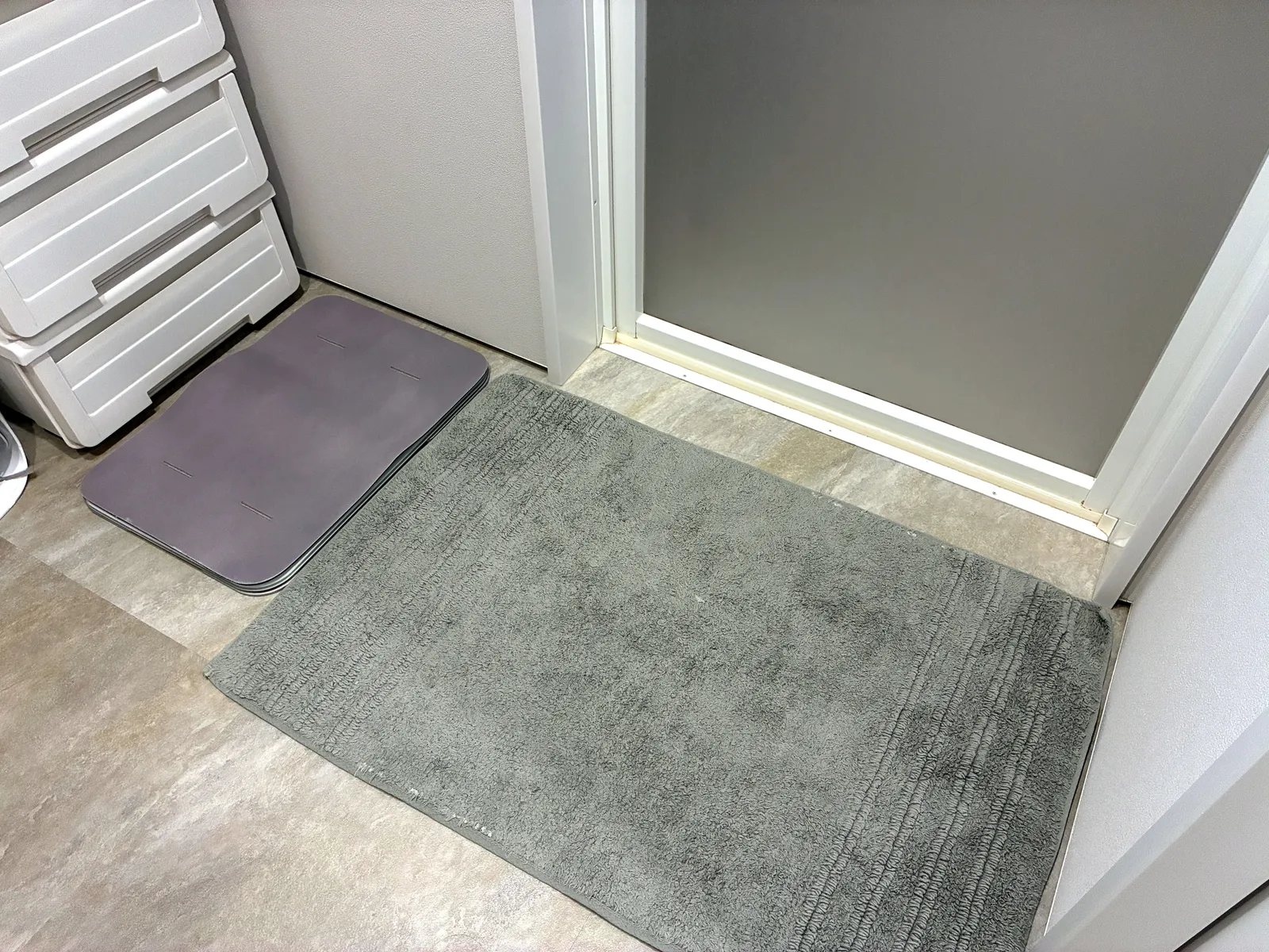 浴室ドアの前に普通のバスマットを敷き、その横にSmart Bath Mat（体組成計モデル）を置いた脱衣所